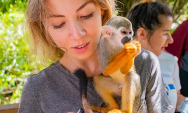Turista con monos ardilla en Monkeyland Punta Cana
