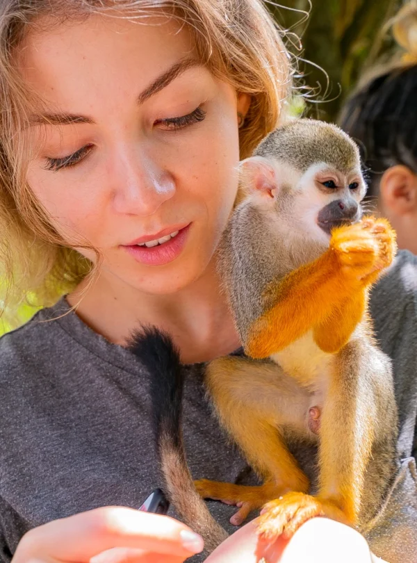 Turista con monos ardilla en Monkeyland Punta Cana