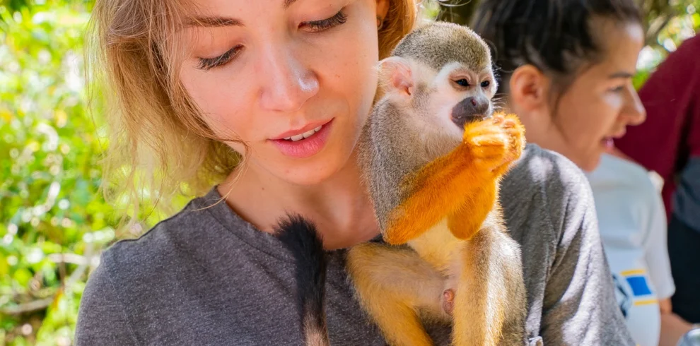 Turista con monos ardilla en Monkeyland Punta Cana